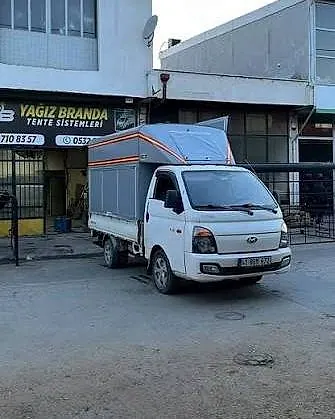 Yağız Branda dükkânının önünde tenteli kamyonet